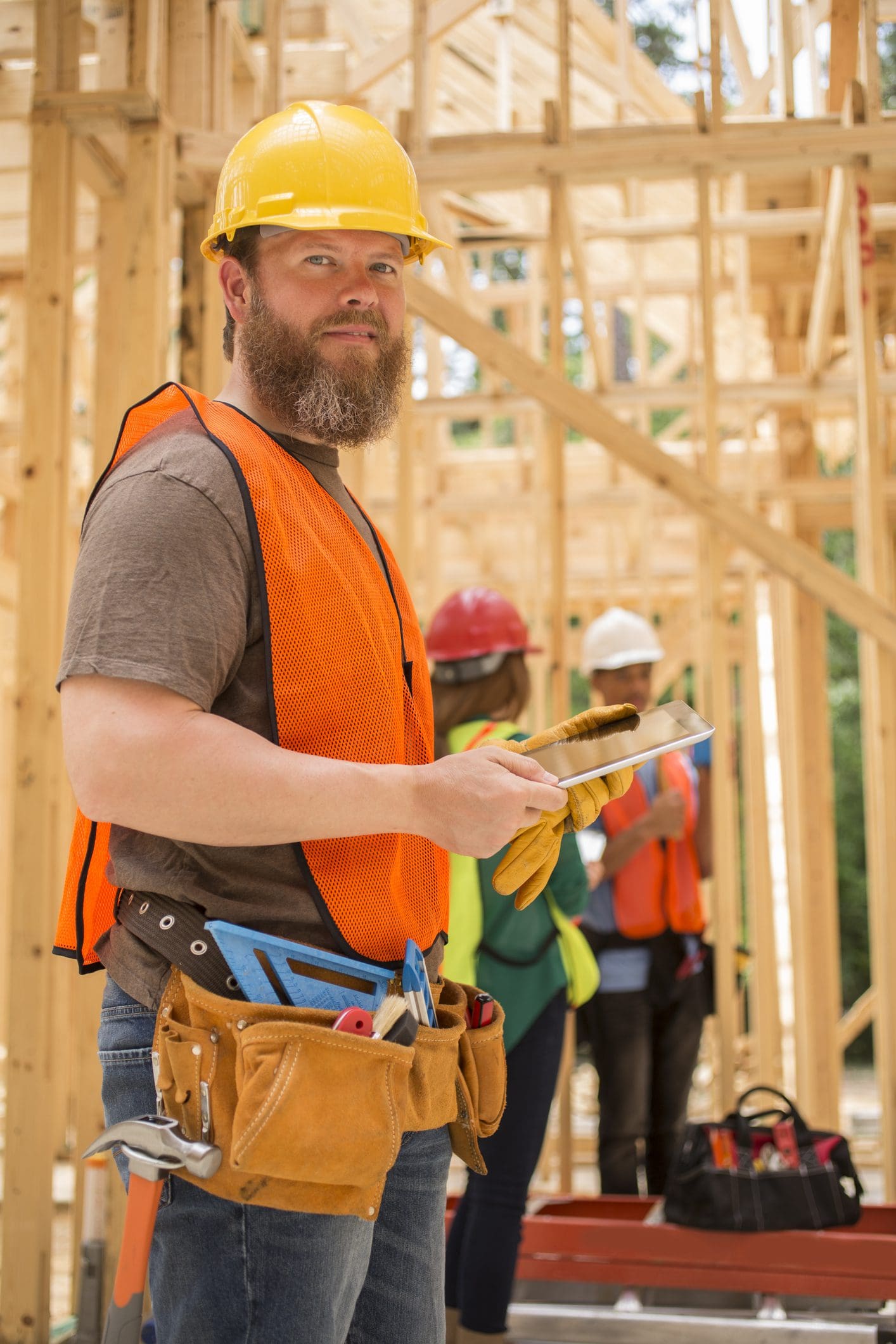 Construction workers working at job site using digital tablet.